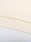 Detailed view of hem stitching on beige Mark the Believer Tee. Durable 100% cotton fabric for long-lasting casual wear.