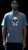 Person wearing a gray t-shirt with a skull design on a black background