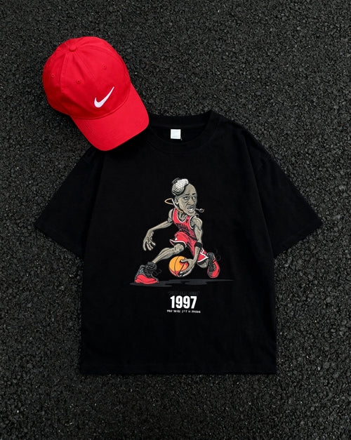 Flat lay of 1997 Flu Game Unisex Seamless Graphic T-Shirt - 230 GSM in black with red Nike cap, showcasing bold basketball-themed print.