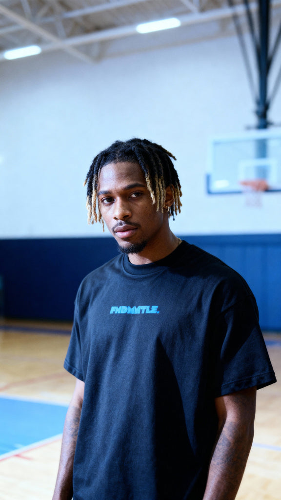 Black Mets Blue T-Shirt - Heavyweight Earth Tone with subtle blue FNDMTLS logo, styled for casual streetwear on basketball court.