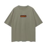 Olive green FNDMNTLS. Shattered Tee with orange chest logo, oversized unisex graphic t-shirt with relaxed fit and drop shoulders.
