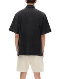 Black short-sleeved heavyweight snow-washed polo with bird emblem and beige shorts