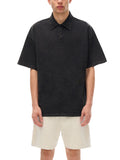 Man wearing heavyweight snow-washed polo t-shirt with bird emblem in black and beige shorts