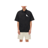 Heavyweight snow-washed polo with bird emblem, unisex casual style, 100% cotton.