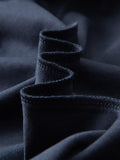 Macro shot of navy cotton blend fabric used in short-sleeve polo shirt, highlighting texture and quality.