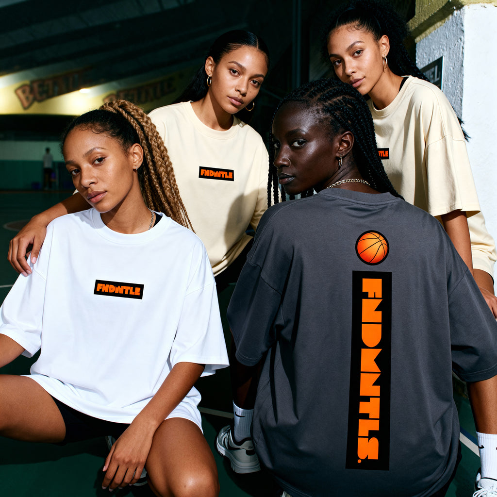 Four individuals wearing 'FIGHTER' branded t-shirts in an outdoor setting.