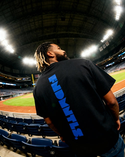 Side view of black Mets Blue T-Shirt - Heavyweight Earth Tone with vertical FNDMTLS logo. Perfect for casual and sporty looks.