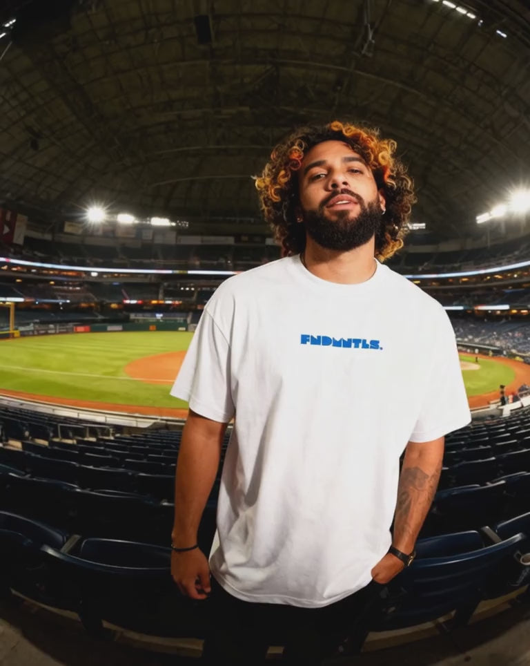 White Mets Blue T-Shirt - Heavyweight Earth Tone with FNDMTLS logo, styled in stadium setting. Unisex cotton casual streetwear.
